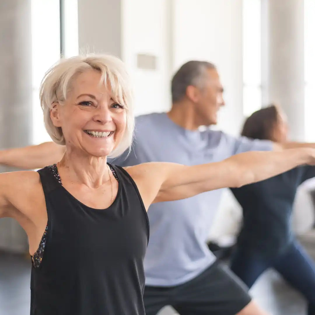 Lachende vrouw die met anderen aan het sporten is.